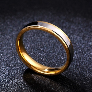 Detail view of two-tone gold and silver polished stainless steel ring on black background