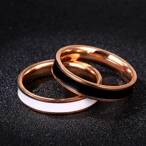 Macro view of 18k rose gold titanium steel rings with black and white enamel details