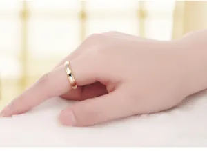 Macro shot of a two-tone polished stainless steel ring on index finger with warm soft focus