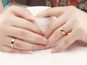 Detail of couple rings in rose gold with white shell inlay worn by a model