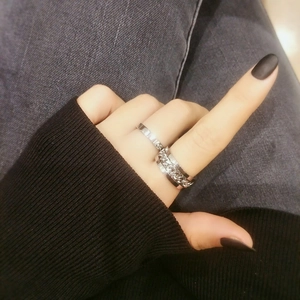 Close-up of minimalist silver chain link and polished metal rings set for couples