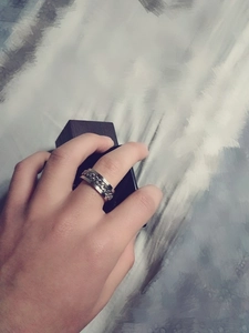 Close-up of a silver titanium steel chain ring worn on hand with industrial design style