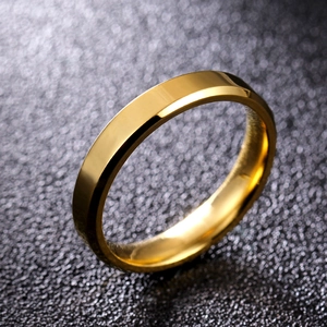 Close-up of golden beveled edge stainless steel ring on a black textured background