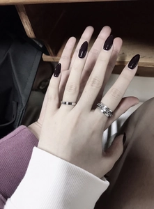 Close-up of minimalist silver titanium steel chain ring and plain band on fingers