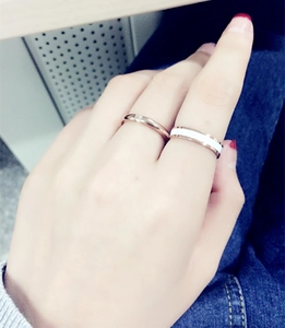 Detailed view of 18k rose gold rings with white enamel inlay and crystal on a hand