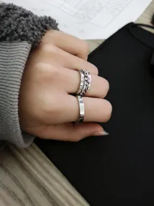 Detail showing a silver chain band and flat ring set on finger for everyday styling
