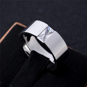 Macro shot of silver metal ring with a rectangular inset gemstone on a black velvet box