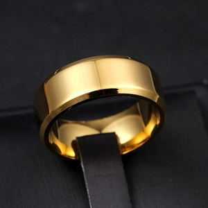Macro shot of 8mm gold polished titanium steel ring with beveled edges on a textured stand