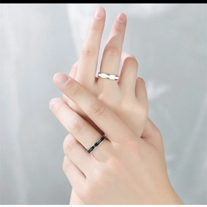 Neutral ceramic rings in black and white with rose gold edges on fingers