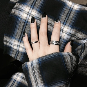 Detail of silver titanium steel rings with flat band and cuban chain texture on finger