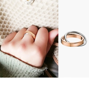 Detailed view of two-tone interlocking rings in rose gold and silver mirror finish