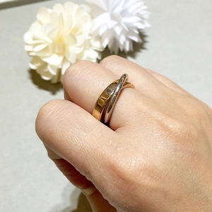 Detail of interlocking 18K three-tone stainless steel bands in gold, silver, and rose gold