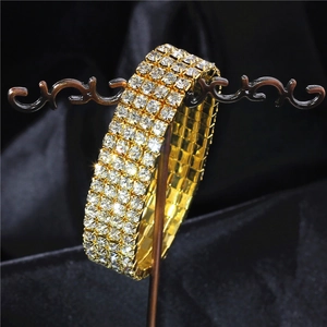 Macro shot of gold elastic wedding bracelet with four rows of sparkling crystals