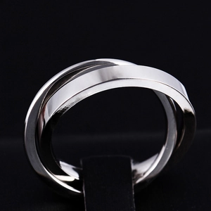 Macro shot of silver triple-band trinity ring in polished stainless steel on black velvet