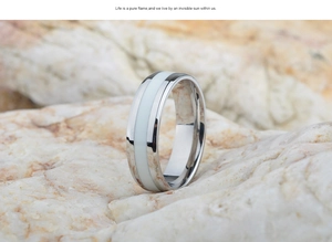 Makrodetail eines 6mm Edelstahlrings mit weißem Emaille-Inlay auf natürlicher Felsstruktur