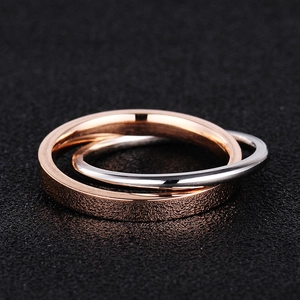 Detail of interlocking matte rose gold and polished silver stainless steel rings