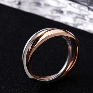 Detailed macro view of interlocking rose gold and silver rings with high polish finish
