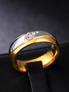 Détail macro d'une bague bicolore en acier titane avec cinq petits cristaux sertis