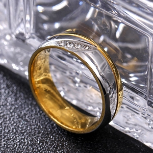 Détail macro d'une bague bicolore en acier inoxydable avec quatre cristaux étincelants