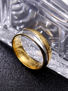 Vue macro d'une bague en acier inoxydable bicolore avec rainure dorée polie