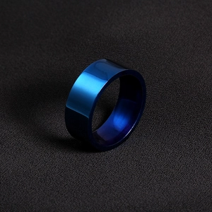 Detailed macro view of 8mm polished deep blue titanium steel ring on black texture