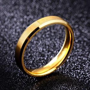 Macro shot of 8mm gold brushed steel ring with polished beveled edges on dark texture