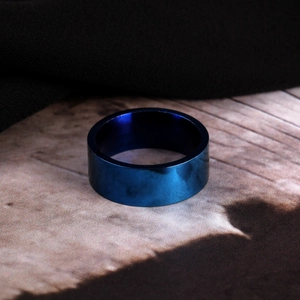 Close-up of 8mm flat edge polished blue stainless steel ring with mirror finish