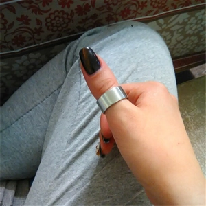 Detailed view of a 10mm wide silver titanium steel ring worn on a thumb for men and women