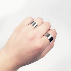 Detailed view of two 10mm wide brushed stainless steel rings worn by a model