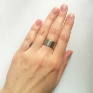 Close-up of a 10mm wide silver titanium steel ring with a brushed finish on a finger