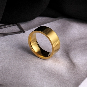 Detailed view of 8mm wide polished gold stainless steel ring on textured background