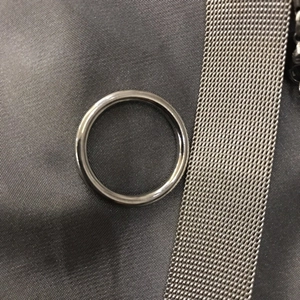 Anillo minimalista de acero inoxidable gris plomo con acabado liso sobre fondo oscuro