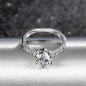 Classic silver-toned ring featuring a brilliant six-prong zircon setting with pavé accents