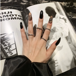 Conjunto de anillos plateados minimalistas con elegante decoración de uñas negro y oro