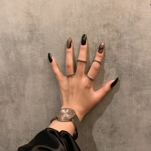 Anillos minimalistas de plata en los nudillos con un reloj de metal cepillado