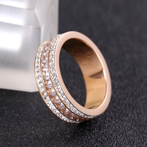 Vue latérale macro d'une bague en or rose avec trois rangées de zircons étincelants