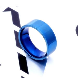 Macro view of 8mm wide blue polished titanium steel ring on geometric display card