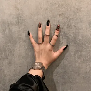 Anillos minimalistas de plata en la mano de una modelo con reloj industrial chic