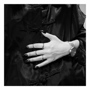 Anillos minimalistas de acero plateado y reloj metálico con atuendo negro vintage