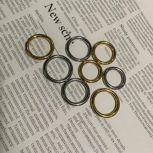 Vista macro de anillos minimalistas de acero de titanio pulido oro y plata en papel