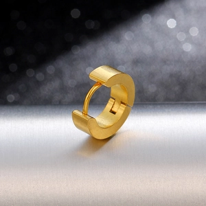 Macro shot of minimalist golden titanium steel hoop earring with a hinge clasp design