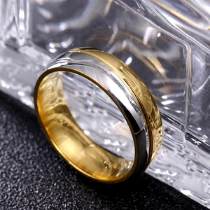 Vue détaillée d'une bague bicolore en acier poli avec gravure centrale linéaire