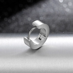 Close-up of brushed titanium steel hoop earring with detailed metal texture for men
