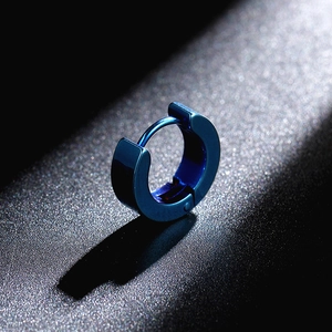 Close-up of polished dark blue titanium steel huggie earring on a black textured background