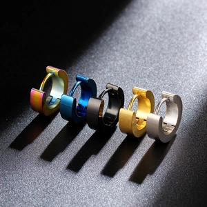 Detailed close-up of five colorful stainless steel huggie earrings on a dark background