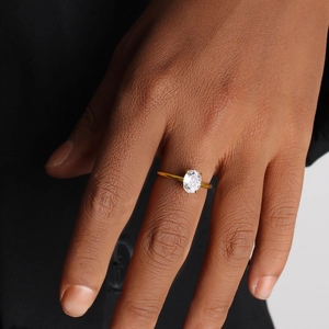 Close-up of 18K gold stainless steel ring featuring an oval zircon on a model hand