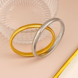 Vista detallada de pulseras elásticas de acero inoxidable en oro y plata con patrón de serpiente