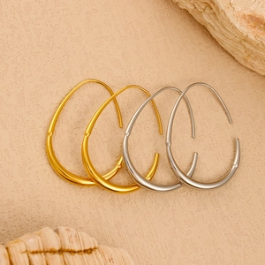 Minimalist gold and silver teardrop hoop earrings on natural stone background