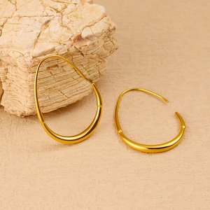 Macro shot of gold-plated geometric hoop earrings featuring bamboo texture and mirror polish