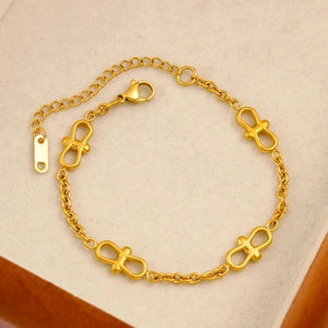 Dettaglio di bracciale in acciaio placcato oro 18k con croci traforate e catenella